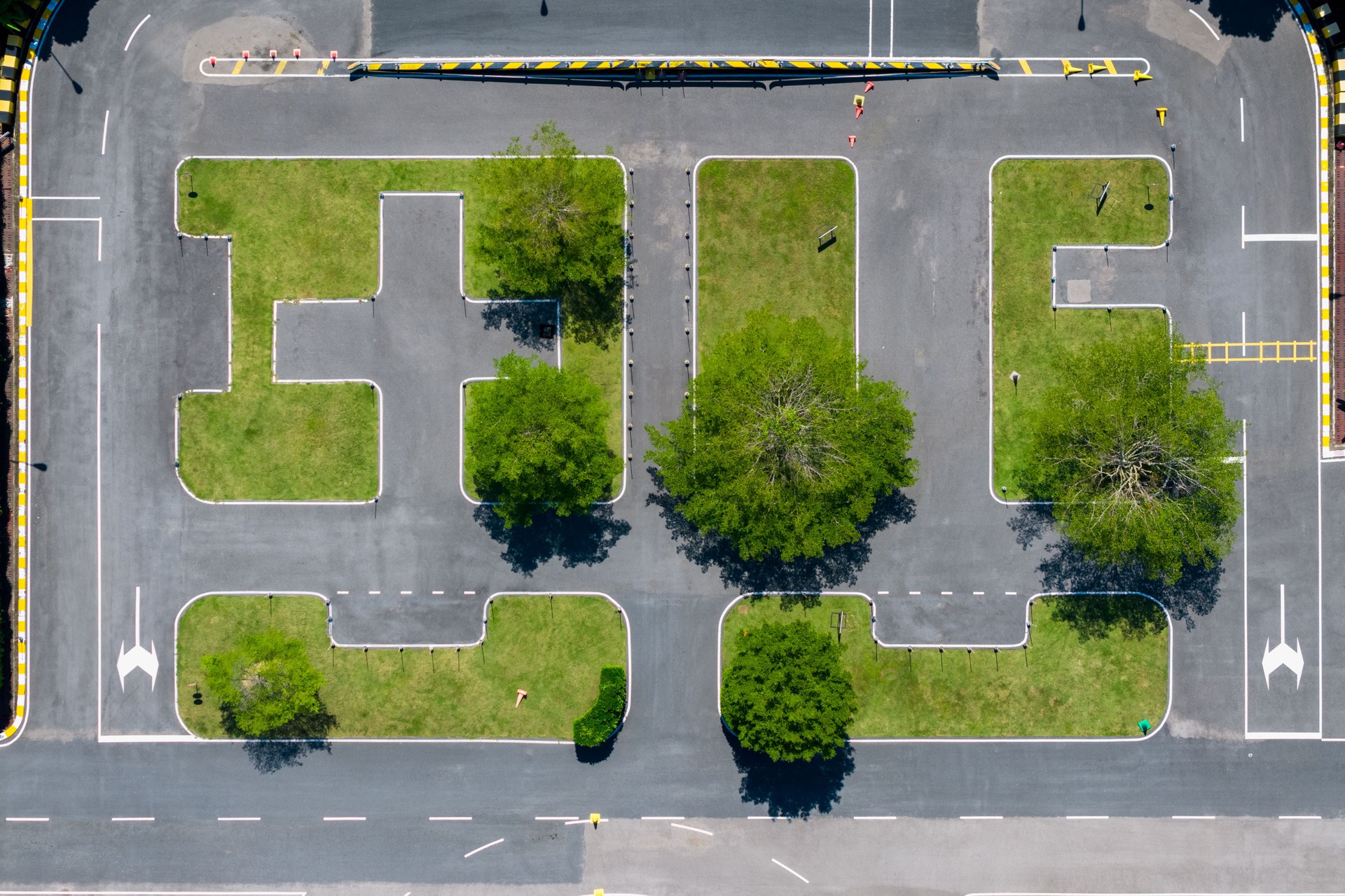 Empty driving school training ground with clear lane markings and obstacles, ready for driving practice and testing.